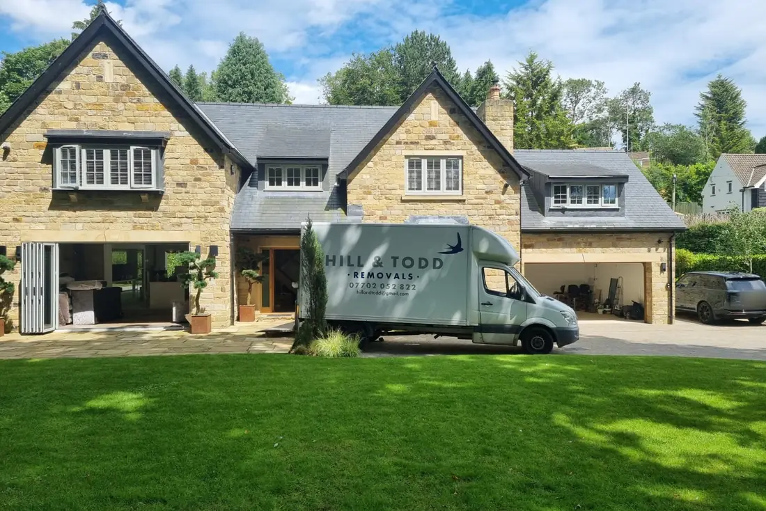 Hill & Todd Removals van on a job outside a stone family house